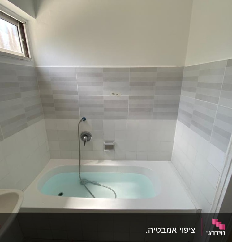 אמבטיה עם חיפוי קיר אריחים אפורים ולבנים